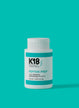 A bottle of K18 PEPTIDE PREP detox shampoo against a teal background.